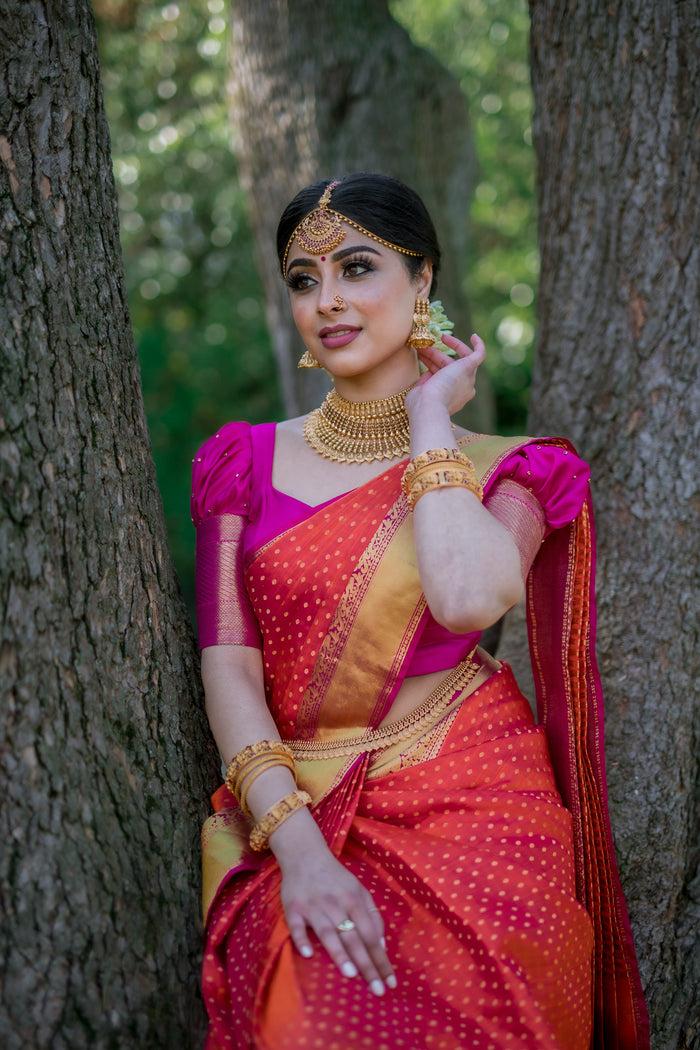 Model wearing a red and gold traditional saree